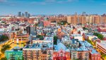 Aerial view of a neighorhood in NYC that includes buildings of many sizes, types and colors.