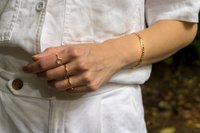 Woman's hand posing with handmade gold jewelry