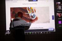 A man presenting in front of a screen.