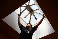 Contractor seals around the skylight window of a home 