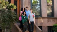 Happy family poses on front stoop of their brownstone