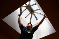 Contractor seals around the skylight window of a home