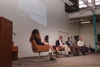 Five panelists sitting on stage at a conference